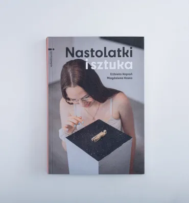 Okładka książki z fotografią młodej, długowłosej dziewczyny przyglądającej się ciekawemu, małemu eksponatowi na postumencie