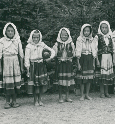 czarno-biała fotografia z pięcioma bosymi dziewczynkami w sukienkach chustach na głowach
