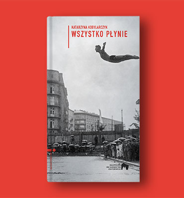 Okładka książki z fotografią skoczka akrobatę w locie, w scenerii miejskiej